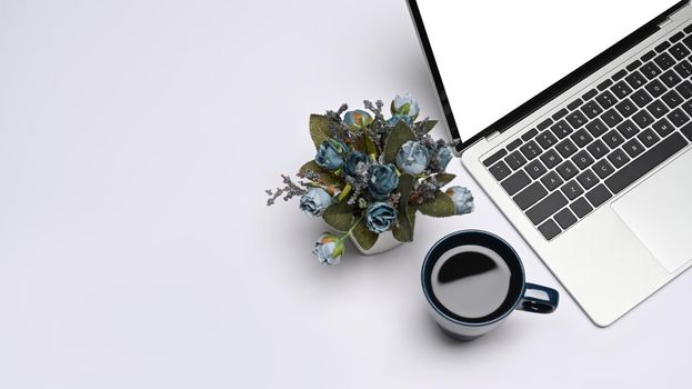 Mockup laptop computer with empty display, coffee cup and flower pot on white background.