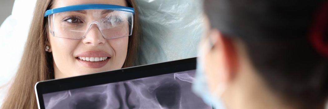 Female doctor orthodontist holds a snapshot of the jaw. Girl on examination at the dentist, dental prosthetics