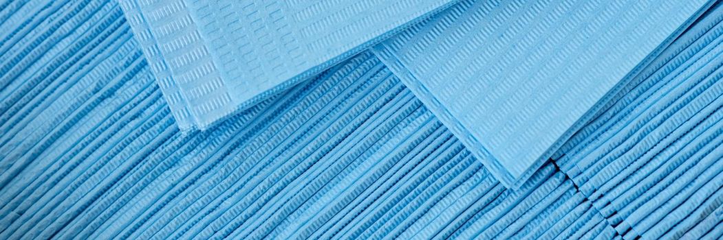 Set of medical disposable napkins for patient examination, close-up. Virus protection during a pandemic, blue paper texture