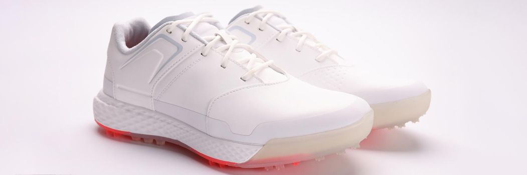 Fashionable women's white sneakers with laces on a paper sheet, close-up. Selling shoes via the Internet, taking photos of trendy things