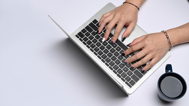 Young businesswoman hands typing on on laptop computer. Top view.