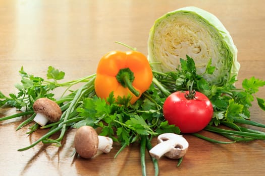 Set of good natural products with fresh cabbage, pepper, tomato, mushrooms, onion and parsley on the table