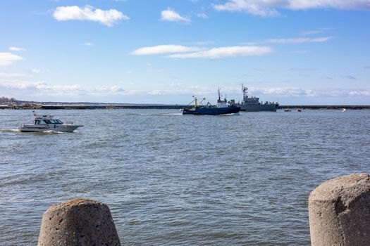 A warship and boats sail through the sea bay in Baltiysk, Kaliningrad region, Russia, near the Baltic sea.