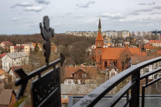 An angel and an arrow on the background of a panoramic view of the city point to the church in Zelenogradsk, Kaliningrad region, Russia, near the Baltic sea. Translation: "Museum".