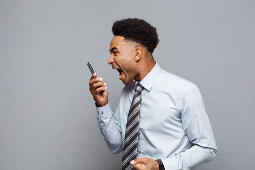 Business Concept - Stressful african american businessman shouting and screaming on mobile phone