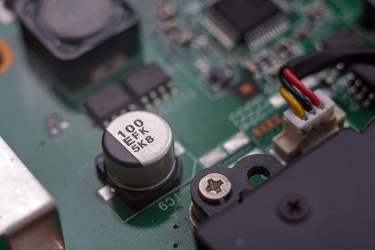 Electronic components. Integrated circuits, resistors, transistors and capacitors on PCB. Green copper board detail. Standard color code. Old computer hardware.