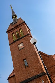 Sightseeing. The red brick church tower is aimed at the blue sky in Zelenogradsk, Kaliningrad region, Russia, near the Baltic sea.