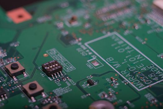 Electronic components. Integrated circuits, resistors, transistors and capacitors on PCB. Green copper board detail. Standard color code. Old computer hardware.