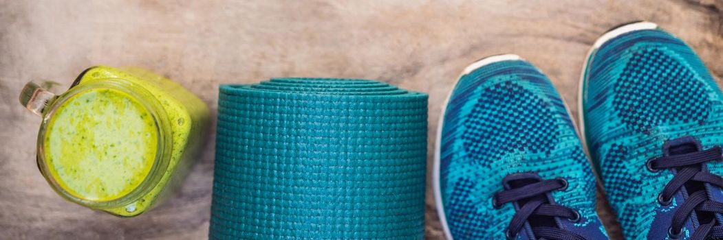 BANNER, LONG FORMAT Everything for sports turquoise, blue shades on a wooden background and spinach smoothies. Yoga mat, sport shoes sportswear and bottle of water. Concept healthy lifestyle, sport and diet. Sport equipment. Copy space.