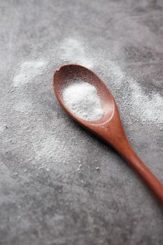 spoon of white sweetener on a black background