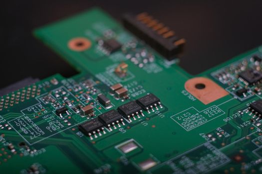 Electronic components. Integrated circuits, resistors, transistors and capacitors on PCB. Green copper board detail. Standard color code. Old computer hardware.