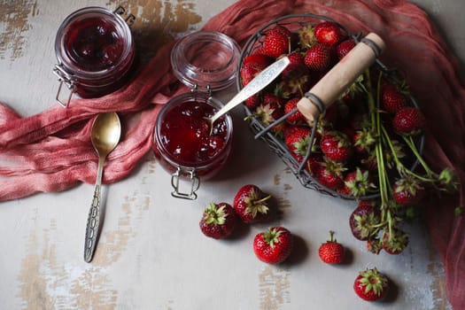 Summer breakfast concept with srawberry jam and fresh harvested berries in a basket, flat lay, copy space.