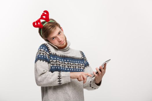 Holiday and Business Concept - Young handsome man busy working on phone and digital tablet.