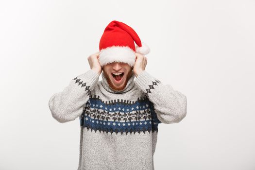 Holiday Concept - Young beard man in sweater enjoy playing with santa hat