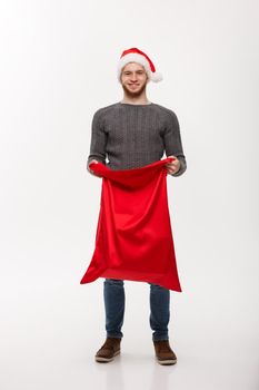 Christmas concept - Young beard handsome man exciting open santa big bag for present.