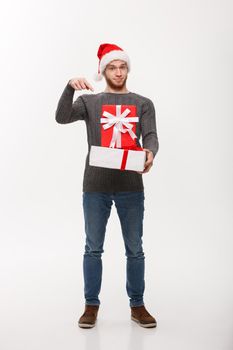 Christmas Concept - Happy young man with beard pointing finger present isolated on white background.