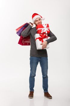 Christmas Concept - attractive young caucasian man enjoy shopping holding a lot of presents in Christmas Day.