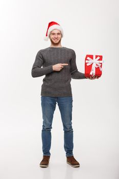 Christmas Concept - Happy young man with beard pointing finger present isolated on white background.