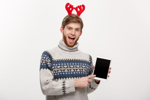 Holiday and Business Concept - Young handsome man showing tablet display and pointing finger presenting.