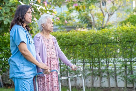 Doctor help and care Asian senior or elderly old lady woman use walker with strong health while walking at park in happy fresh holiday.