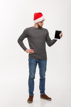 Holiday and Business Concept - Young handsome man looking and showing tablet display for presenting.
