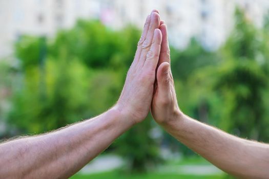 Handshake of men at a meeting in the park. Selective focus. People.