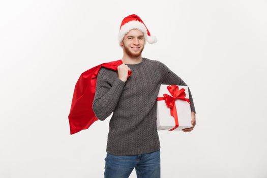 Christmas Concept - Young happy beard man holding santa bag and white present.