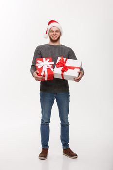 Christmas Concept - Happy young man with beard carries a lot of presents isolated on white background.