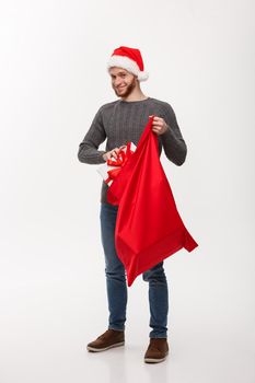 Christmas Concept - Young happy beard man excite with big present in santa bag.
