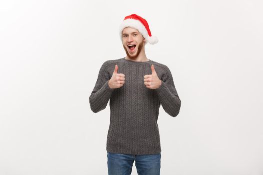 Holiday Concept - Young beard man in sweater giving thumb up to camera.