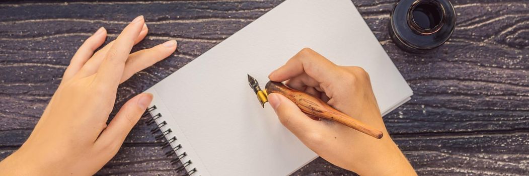 Women's hands in a wooden background holding a signboard, drawing block, paper, mockup. BANNER, LONG FORMAT