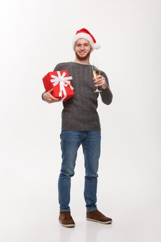 Christmas Concept - Happy young man with beard holding present and champagne celebrating for Christmas isolated on white background.