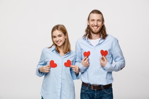 Couple in love holding red paper hearts.