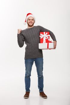 Christmas Concept - Happy young man with beard holding present and hand up isolated on white background.