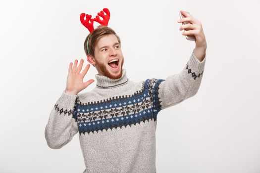 holiday and lifestyle concept - Young handsome beard man taking a selfie or talking facetime with friend.