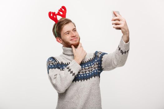 holiday and lifestyle concept - Young handsome beard man taking a selfie or talking facetime with friend.