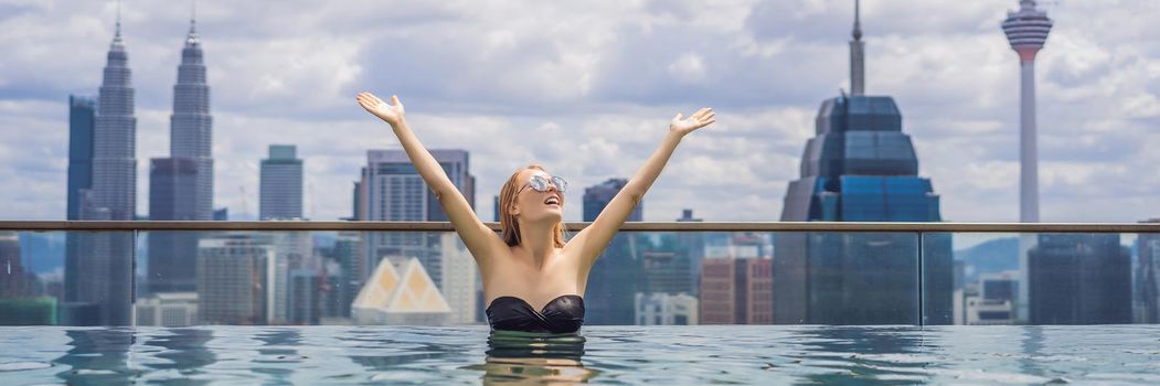 Young woman in outdoor swimming pool with city view in blue sky. Rich people. BANNER, LONG FORMAT
