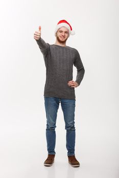 Holiday Concept - Young beard man in sweater giving thumb up to camera.