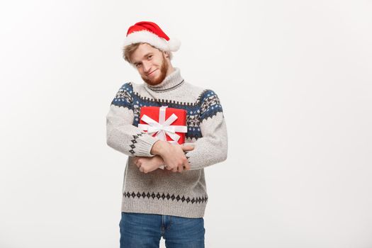 Christmas Concept - Happy young man with beard carries present isolated on white background.