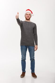 Holiday Concept - Young beard man in sweater giving thumb up to camera.