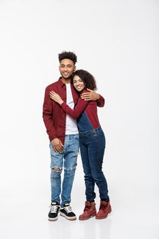 Full body portrait of young African American hugging couple, with smile. Dating, flirting, lovers, romantic studio concept, isolated on white background