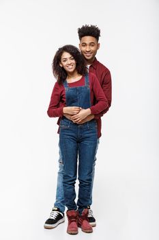 Full body portrait of young African American hugging couple, with smile. Dating, flirting, lovers, romantic studio concept, isolated on white background