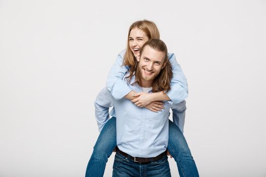 Portrait of smiling man giving happy woman a piggyback ride