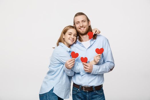 Couple in love holding red paper hearts.