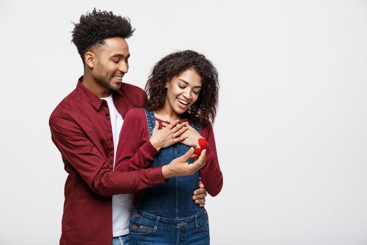 Young handsome african american man surprisingly ask her girlfriend for proposal