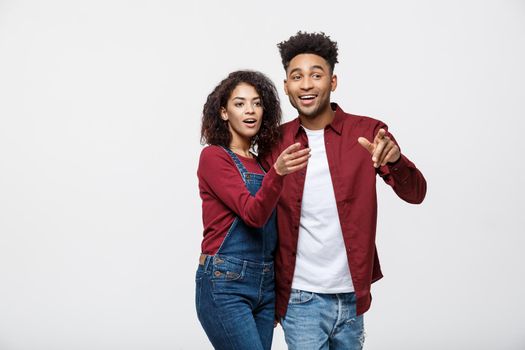 Young African American people in casual clothes looking away and point finger. isolated on white background.