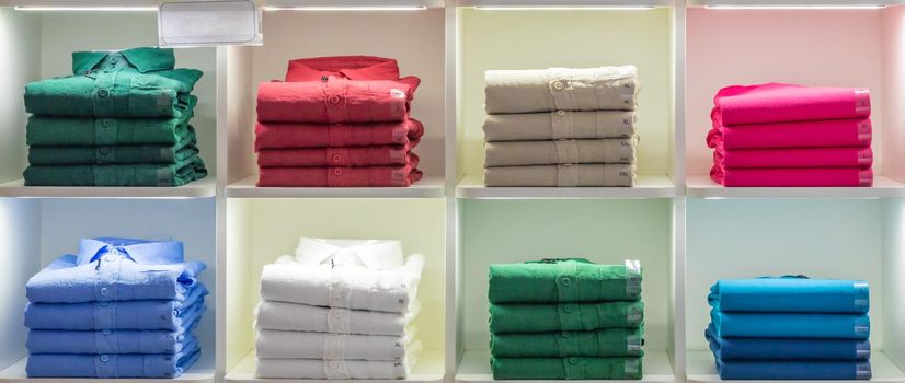 Polo t-shirt store interior. Shop shelves with  colored fashion cotton shirts.