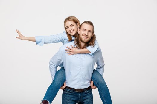 Portrait of smiling man giving happy woman a piggyback ride