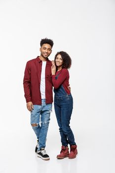Full body portrait of young African American hugging couple, with smile. Dating, flirting, lovers, romantic studio concept, isolated on white background
