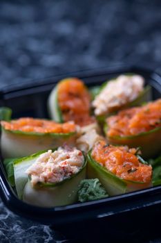 set of sushi rolls with seafood on a black stone background